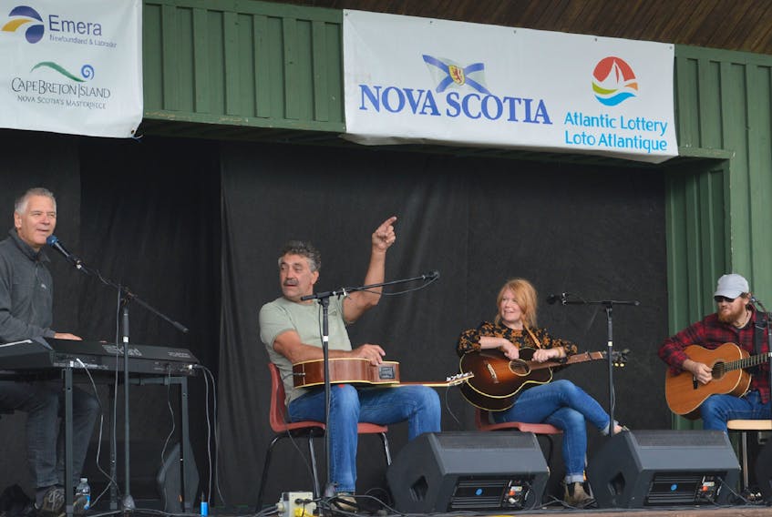John Curtis Sampson, second from left, prompts the crowd to sing along with Kim Dunn, left, as Norma MacDonald and Jason MacDonald look on during a songwriters circle segments of the Acoustic Roots Festival on Sunday afternoon at Two Rivers Wildlife Park. — IAN NATHANSON/CAPE BRETON POST 