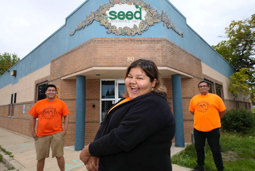 Money Stories facilitators Justin Huntinghawk, Calandra Necan, and Andrew Proulx-Courchesne (from left) pose in front of the SEED Winnipeg office on Salter Street on Thursday, Sept. 2, 2021.