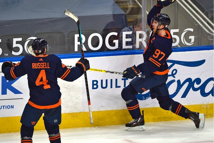 Edmonton Oilers Connor McDavid (97) celebrates what turns out to be the winning goal with Kris Russell (4) defeating the Calgary Flames 3-2 during NHL action at Rogers Place in Edmonton, March 7, 2021. 