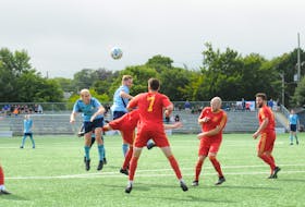Feildians and Holy Cross players vie for an airborne ball near midfield during Sunday’s Johnson Insurance Challenge Cup provincial men’s soccer final at King George V Park in St. John’s. Feildians prevailed 2-1 to take their first Challenge Cup crown since 1969. — Joe Gibbons/The Telegram