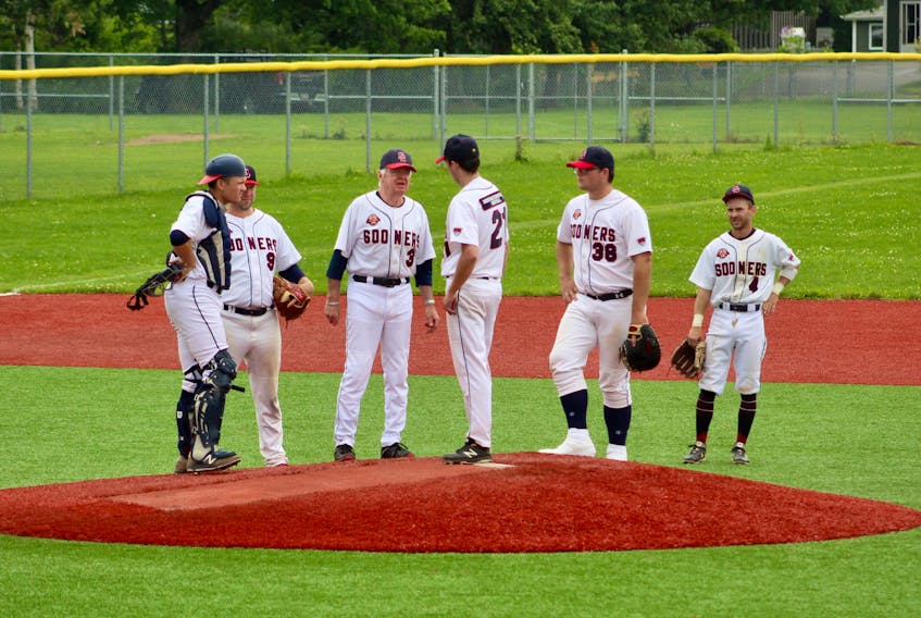 Sydney Sooners manager Jim (Rico) McEachern, third from left, is hoping to guide his squad to a seventh Nova Scotia Senior Baseball League title. The Sooners lead the Kentville Wildcats 2-0 in their best-of-five semifinal series. Above, McEachern chats with rookie hurler Parker Hanrahan on the mound during an August match against the Dartmouth Moosehead Dry in Sydney. From left: catcher Jordan Sampson, third baseman Guy Pellerine, McEachern, Hanrahan, first baseman Brett Sibley and shortstop Chris Farrow. DAVID JALA/CAPE BRETON POST