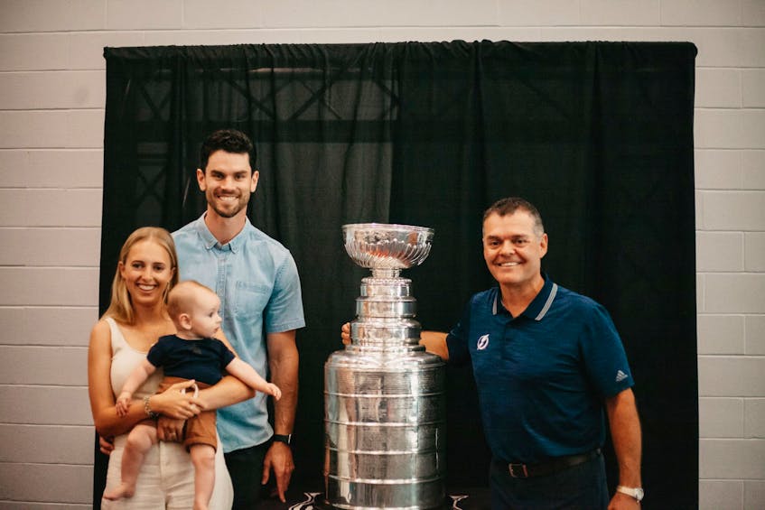Adam McQuaid, back left, his wife, Stephanie, and their son, Roman, were invited by Summerside's Grant Sonier, right, to a Stanley Cup reception at Credit Union Place. Sonier, an amateur scout with the Tampa Bay Lightning, recently had a day with the Stanley Cup as part of its summer tour to the NHL champions. Sonier worked with the Bruins when Boston acquired McQuaid in a trade with the Columbus Blue Jackets in May 2007. - Millicent Lee Photography/Special to The Guardian