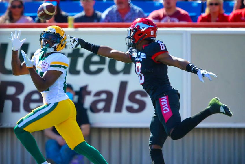 The Edmonton Elks’ Earnest Edwards makes a touchdown catch in front of the Calgary Stampeders’ DaShaun Amos at McMahon Stadium on Monday, Sept. 6, 2021. 