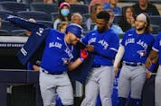 Blue Jays' Alejandro Kirk gets his home run jacket with help from Teoscar Hernandez as Bo Bichette looks on after Kirk hit a home run against the New York Yankees during the eighth inning of a game at Yankee Stadium on Wednesday, Sept. 7, 2021.