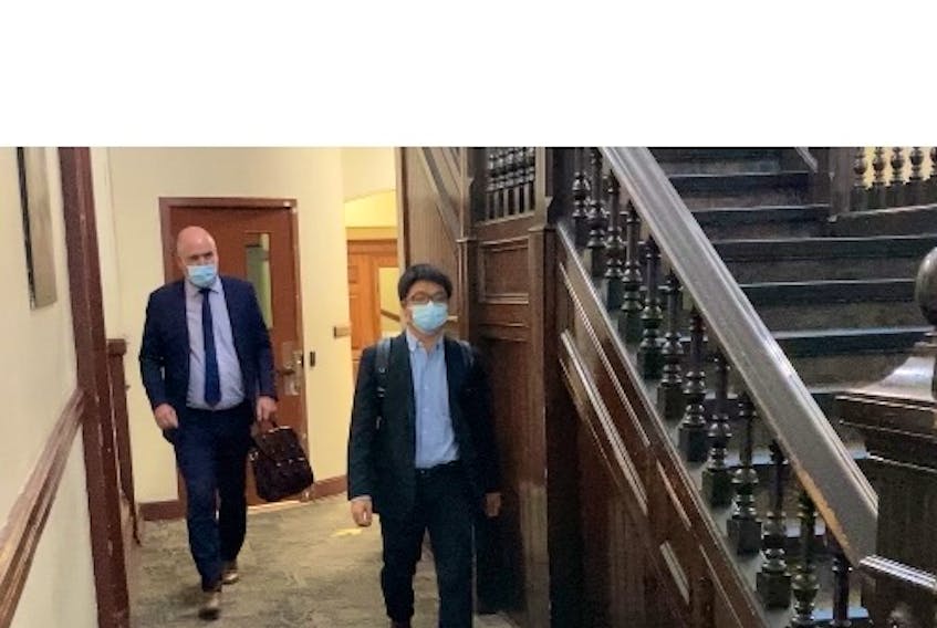 Halifax acupuncturist Xiao Han Li leaves court with lawyer Ian Hutchison on Thursday after his sexual assault trial, which got underway Tuesday, was adjourned to allow defence co-counsel Mark Knox to get a COVID-19 test.