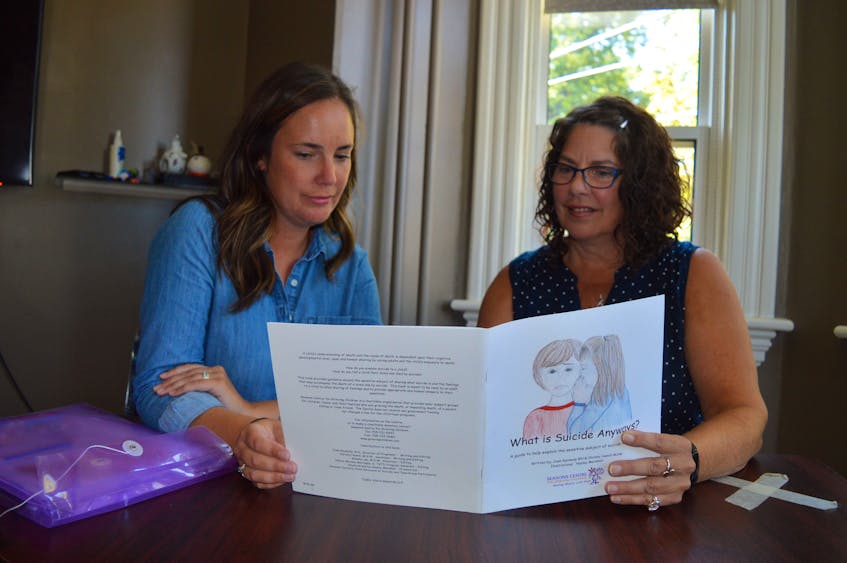 Pat Doyle, right, manager of suicide prevention and life promotion for the Canadian Mental Health Association in P.E.I., and Jocelyne Ludgate look at a book entitled What is Suicide Anyways that is designed to help children deal with the impact of suicide. Ludgate is a member of a committee that has put a new resource kit together, Supporting Children and Youth to Grieve After Suicide Loss. - Dave Stewart