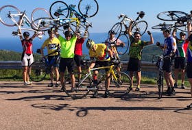 This file photo shows a participants in a previous annual Recovery Ride lifting their bikes above their heads at the top of MacKenzie Mountain on the Cabot Trail. The fundraiser, in its 18th year, has raised more than $50,000 for various Cape Breton charities and organizations. FILE PHOTO/CAPE BRETON POST