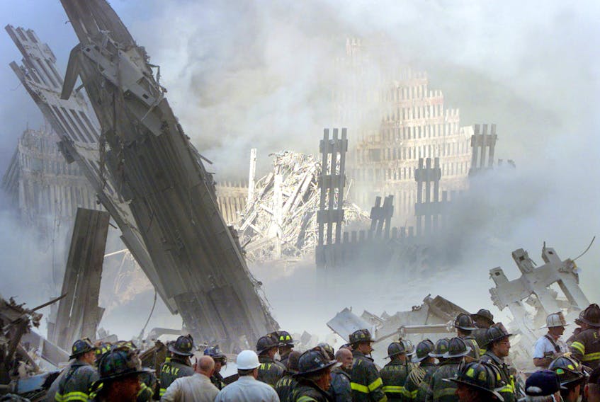 A group of firefighters stand on the street near the destroyed World Trade Centre in New York on September 11, 2001. REUTERS/Shannon Stapleton/File photo