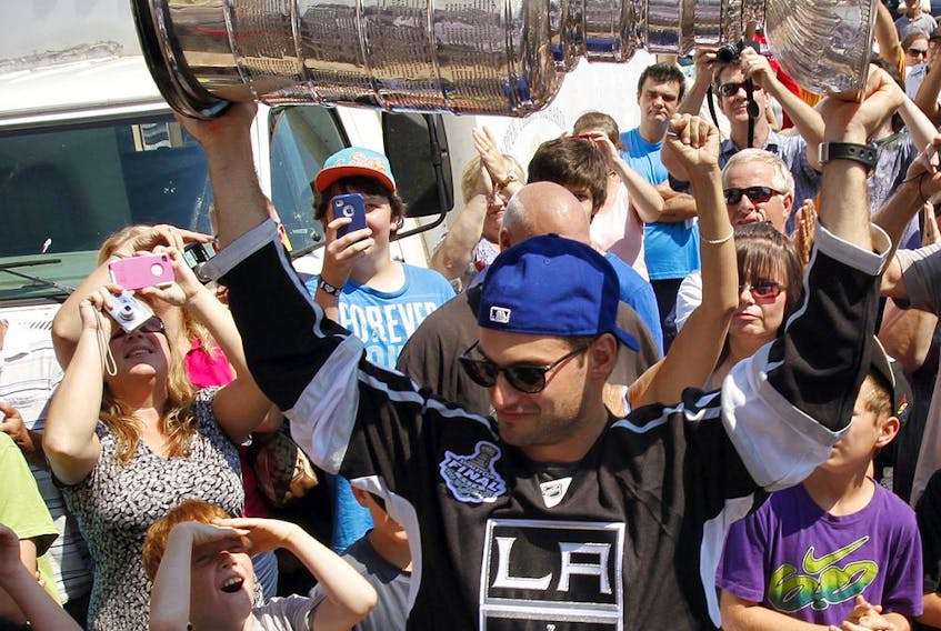 Then-Los Angeles Kings forward Brad Richardson hoists the Stanley Cup before hundreds of fans as he arrives with the coveted NHL trophy at Market Square in downtown Belleville, Ont., in this photo from Aug. 25, 2012.