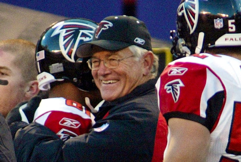 Falcons coach Dan Reeves (C) gets a hug from wide receiver Peerless Price (L) at the end of the Falcons 27-7 win over the New York Giants in their game November 9, 2003. Reeves won his 200th career NFL game. 