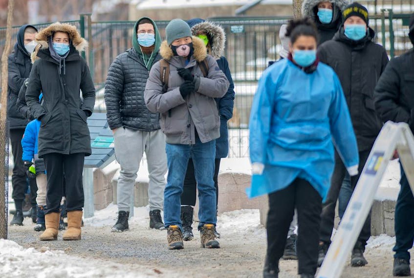  People wait in line at a COVID-19 testing and vaccination site in Montreal, Wednesday, December 29, 2021, as the COVID-19 pandemic continues in Canada