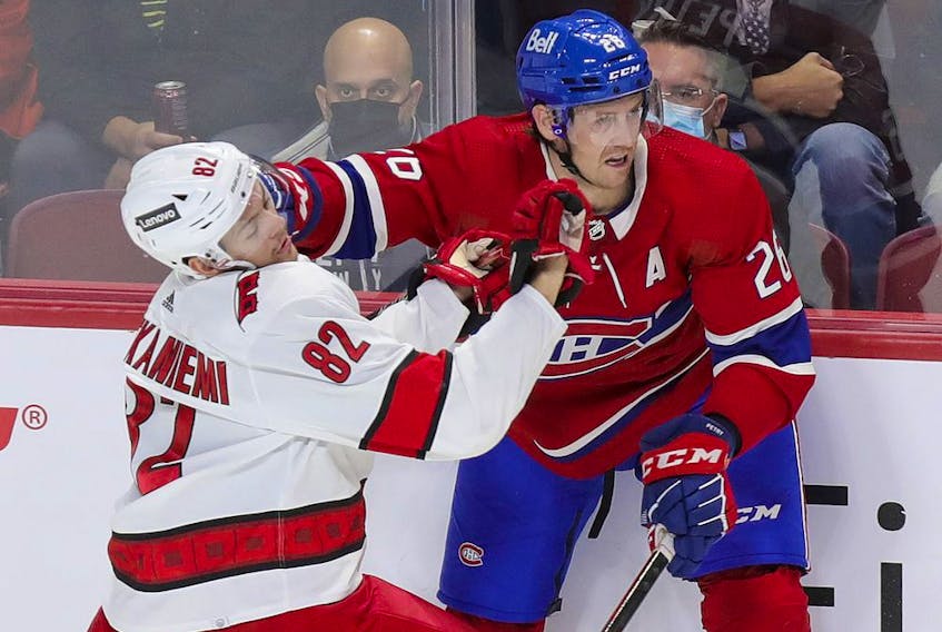 Montreal Canadiens defenceman Jeff Petry keeps Carolina Hurricanes' Jesperi Kotkaniemi at bay during first period in Montreal on Oct. 21, 2021.