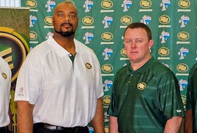 Stephen McAdoo (left) and Chris Jones appear in a photo of the Edmonton Elks coaching staff in 2014.