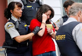 Angry residents shout obscenities as Penny Boudreau is led from court to a waiting car after her appearance in the first-degree murder case in Bridgewater on Monday, June 16, 2008.