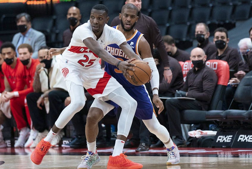 Raptors forward Chris Boucher (25) controls the ball as Phoenix Suns guard Chris Paul (3) defends during the fourth quarter at Scotiabank Arena on Tuesday. 
