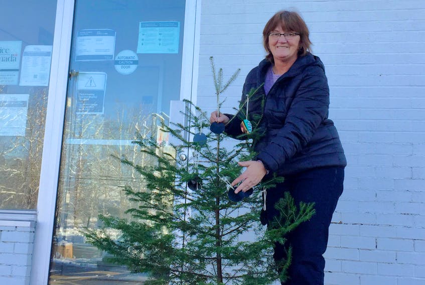 Cape Sable Island plant worker Mandy Symonds was among the seasonal worker representatives in Eastern Canada who placed Christmas trees decorated with black ornaments outside Service Canada offices on Dec. 20 to remind the federal government that once again this year, a great number of workers from the seasonal industry will be confronted to a “Black Hole” since the long awaited and frequently promised reform in the Employment Insurance program has not yet been implemented. Contributed