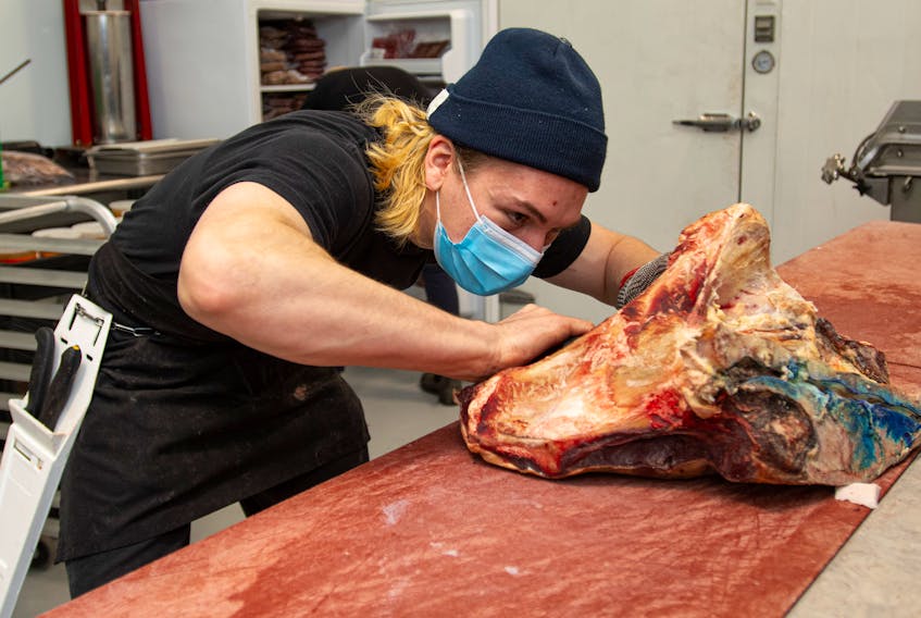 Butcher Nick Comeau cuts into some top sirloin at Getaway Farm's new Osprey's Roost store on Oxford Street on Wednesday, Jan. 12, 2022.