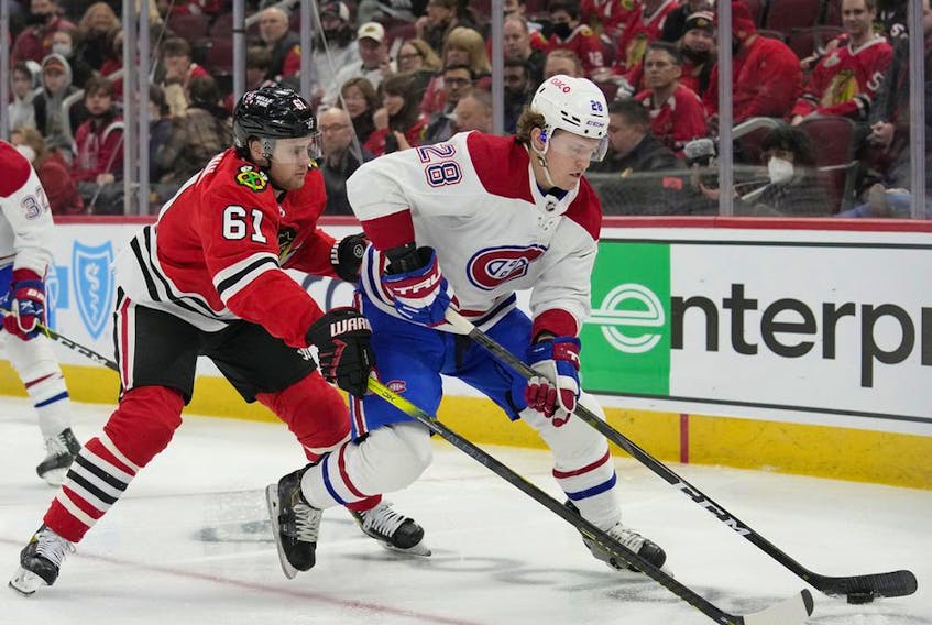 Canadiens' Christian Dvorak controls the puck against Blackhawks' Riley Stillman during the first period Thursday night in Chicago.