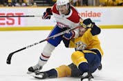 Montreal Canadiens defenceman Alexander Romanov collides with Nashville Predators centre Luke Kunin on Dec. 4, 2021, in Nashville.