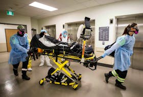 Paramedics and health-care workers transfer a patient from Humber River Hospital's Intensive Care Unit to a waiting air ambulance as the hospital frees up space In their ICU unit, in Toronto on April 28, 2021. 
