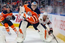 Goaltender Stuart Skinner (No. 74) of the Edmonton Oilers battles against Dylan Gambrell (No. 27) of the Ottawa Senators during the first period at Rogers Place on January 15, 2022. 