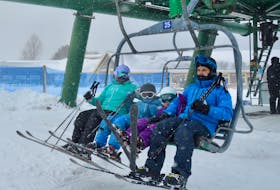 The Williams family settles in on the chairlift for their second run of the day on Sunday at Ski Ben Eoin. From left, Sarah, Henry, Fiona and Blair Williams raise their ski tips as the chair begins to climb the mountain. DAVID JALA/CAPE BRETON POST