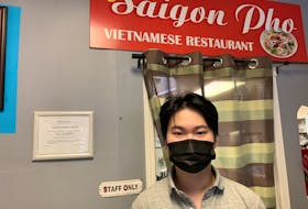Saigon Pho owner Kevin Huynh stands inside his restaurant where he says that some days, he sees one or two customers dine-in. 