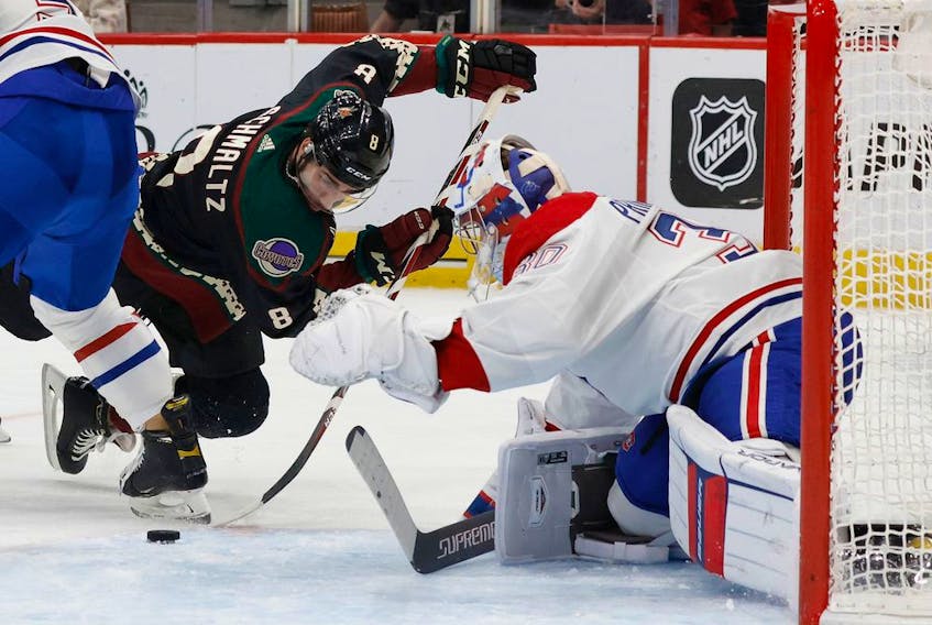 Nick Schmaltz #8 of the Arizona Coyotes attempts to play the puck on goaltender Cayden Primeau #30 of the Montreal Canadiens during the second period of the NHL game at Gila River Arena on Jan. 17, 2022 in Glendale, Arizona.
