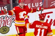  The Calgary Flames’ Sam Bennett celebrates scoring on the Winnipeg Jets with Mikael Backlund at Scotiabank Saddledome in Calgary on March 27, 2021.