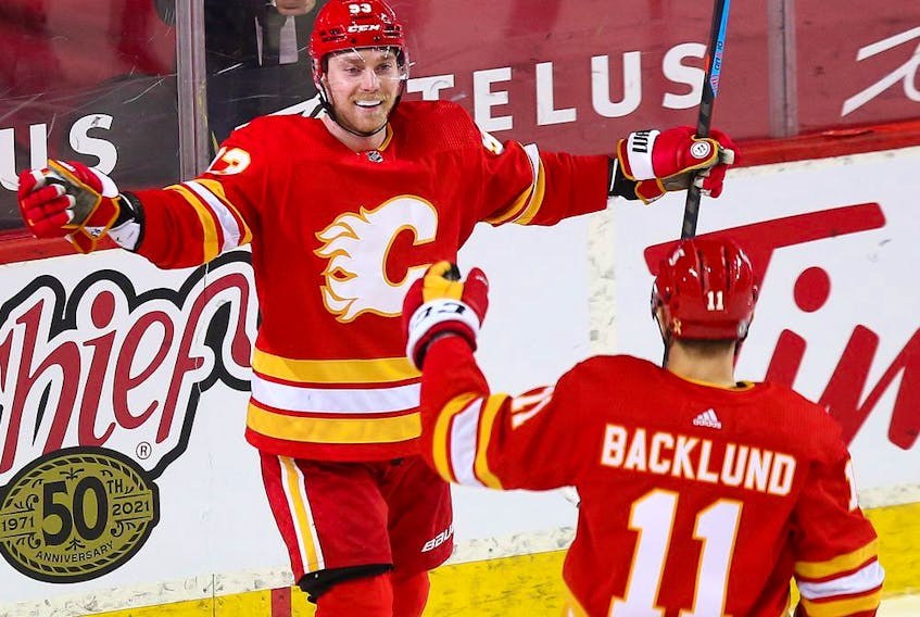  The Calgary Flames’ Sam Bennett celebrates scoring on the Winnipeg Jets with Mikael Backlund at Scotiabank Saddledome in Calgary on March 27, 2021.