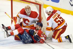 Florida Panthers forward Jonathan Huberdeau reacts after falling to the ice in front of Calgary Flames goaltender Jacob Markstrom and defenceman Noah Hanifin at FLA Live Arena in Sunrise, Fla., on Jan. 4, 2022. 