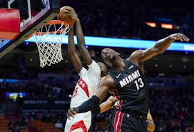 Raptors' forward Chris Boucher (left) dunks over Miami Heat's Bam Adebayo during the first half on Monday, Jan. 17, 2022, in Miami. 