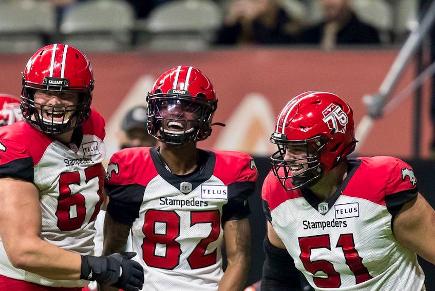 Calgary Stampeders (from left) Zack Williams, Malik Henry and Sean McEwen celebrate Henry's touchdown against the B.C. Lions during a game in Vancouver in this photo from Nov. 12, 2021.