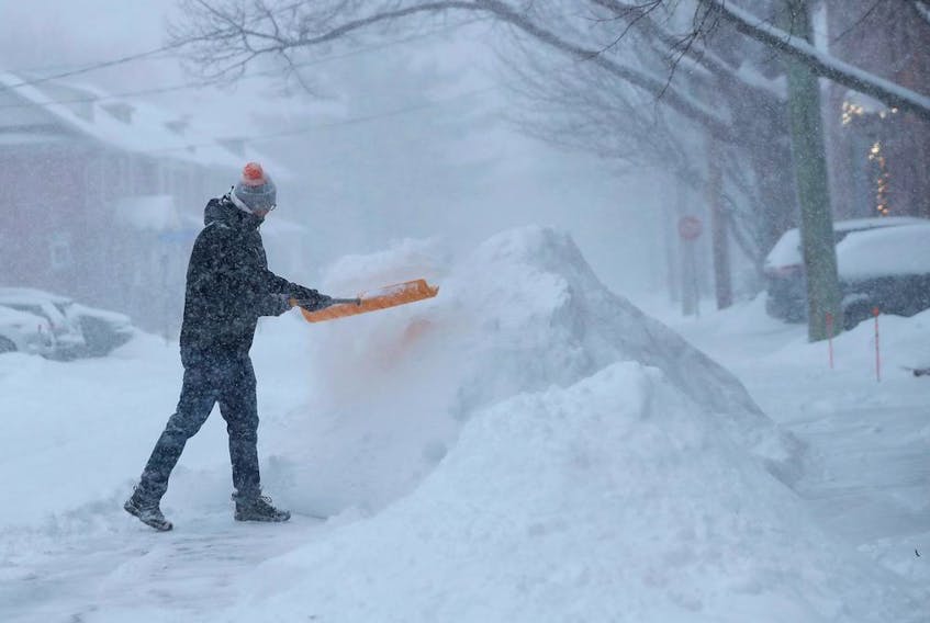 Edward Luff shovelling the snow on McGillivray St. Monday, January 17, 2022. 