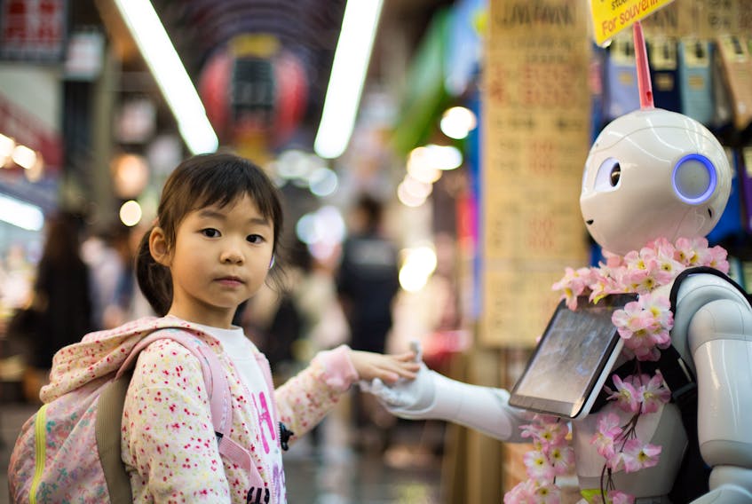 Computer-brain interfaces are no longer science fiction. Here, a girl interacts with a robot at Kuromon Market in Osaka. Andy Kelly photo/Unsplash