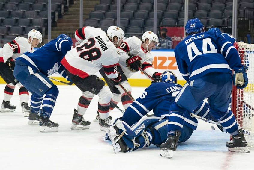 Ottawa Senators right wing Connor Brown watches as teammate Alex Formenton (top) tries, but fails to slide the puck past Toronto Maple Leafs goaltender Jack Campbell at Scotiabank Arena. USA TODAY Sports