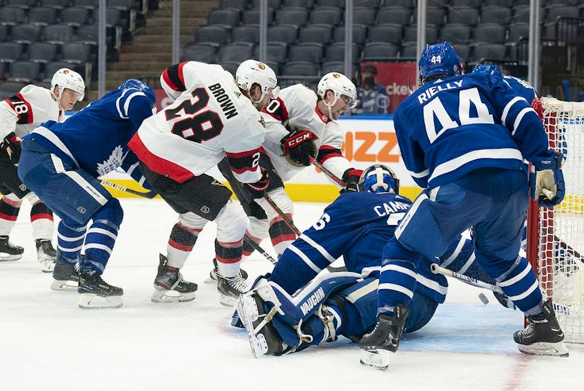 Senators right-winger Connor Brown (28) watches as teammate Alex Formenton (top) tries, but fails to slide the puck past Toronto Maple Leafs goaltender Jack Campbell (36) during the second period of Saturday's game.