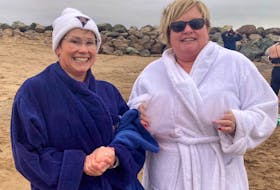 Twin sisters Nicole MacEachern , left, and Natalie Larade dry off after participating in a New Year's Day Polar Bear Dip in Port Hood. CONTRIBUTED/COURTESY NATALIE LARADE