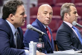 Kent Hughes, centre, listens to Jeff Gorton, the Canadiens' executive vice-president of hockey operations, left, as owner Geoff Molson looks on.