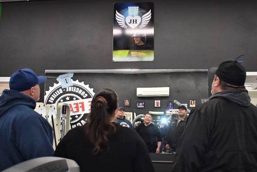 New Beginnings Gym owners Troy (left) and Tracy Ferguson are joined by Jackson Haight’s father Richard, as they glance up at the poster remembering Jackson who passed away on Dec. 24.