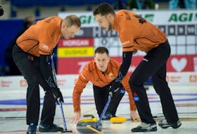 Skip Brad Gushue follows a shot as Geoff Walker, left, and Brett Gallant prepare to sweep at the Canadian Olympic curling trials in November.