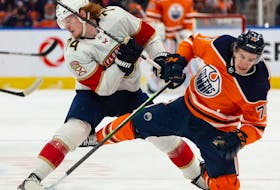 Edmonton Oilers’ Ryan McLeod (71) is hit by Florida Panthers’ Owen Tippett (74) at Rogers Place in Edmonton on Thursday, Jan. 20, 2022.