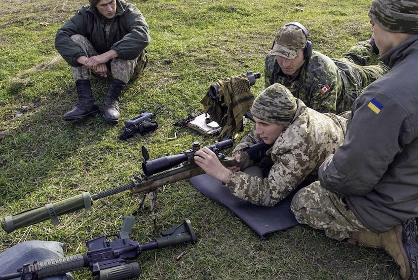  A Canadian soldier coaches Ukrainians on how to operate Canadian small arms at the International Peacekeeping and Security Centre in Starychi, Ukraine, in this file photo from 2015.