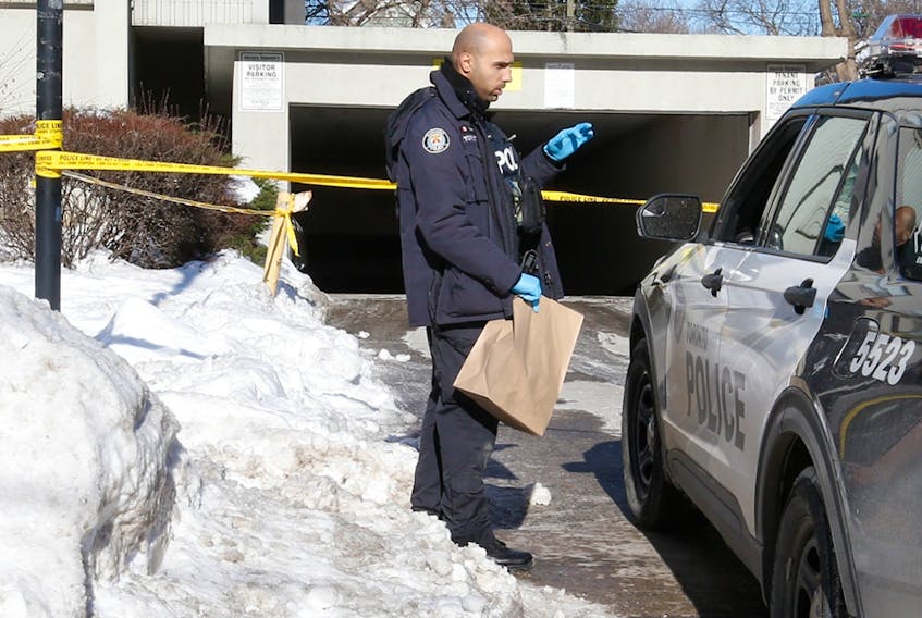  A Toronto Police officer brings an evidence bag into the underground parking garage at 72 Gamble Ave. on Thursday, Jan. 20, 2022, the day after the fatal shooting of 15-year-old Jordon Carter. Jack Boland/Toronto Sun