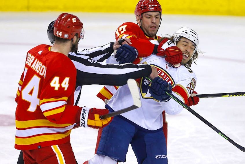The Calgary Flames’ Milan Lucic battles the Florida Panthers’ Ryan Lomberg at Scotiabank Saddledome in Calgary on Tuesday, Jan. 18, 2022.