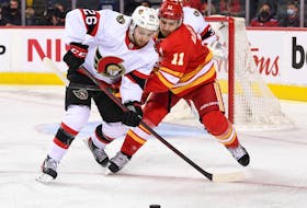 Ottawa Senators defenceman Erik Brannstrom (26) battles for the puck with Calgary Flames forward Mikael Backlund (11) during the third period at Scotiabank Saddledome. Senators won 4-1.