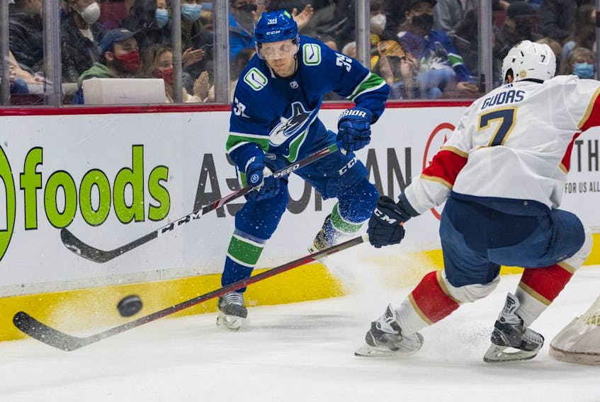 Vancouver Canucks forward Alex Chiasson passes the puck around Florida Panthers defenseman Radko Gudas  in the first period at Rogers Arena. The Canucks lost 2-1 in a shootout.