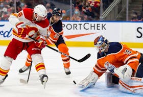 Edmonton Oilers goaltender Mikko Koskinen makes a save against the Calgary Flames’ Brad Richardson at Rogers Place in Edmonton on Saturday, Jan. 22, 2022.