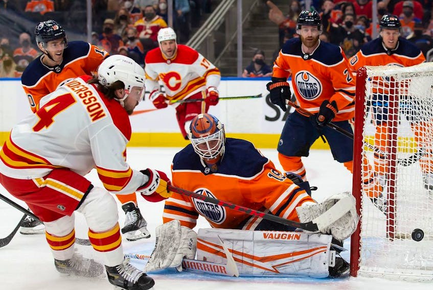 EDMONTON, AB - JANUARY 22: Rasmus Andersson #4 of the Calgary Flames takes a shot against goaltender Mikko Koskinen #19 of the Edmonton Oilers during the first period at Rogers Place on January 22, 2022 in Edmonton, Canada.