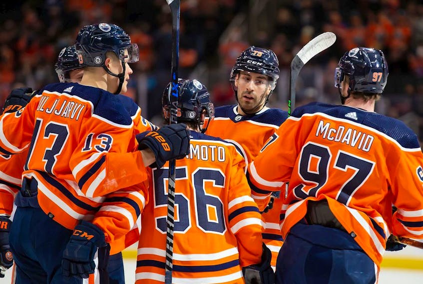 EDMONTON, AB - JANUARY 22: Jesse Puljujarvi #13, Kailer Yamamoto #56, Evan Bouchard #75 and Connor McDavid #97 of the Edmonton Oilers celebrates a goal against the Calgary Flames during the second period at Rogers Place on January 22, 2022 in Edmonton, Canada.